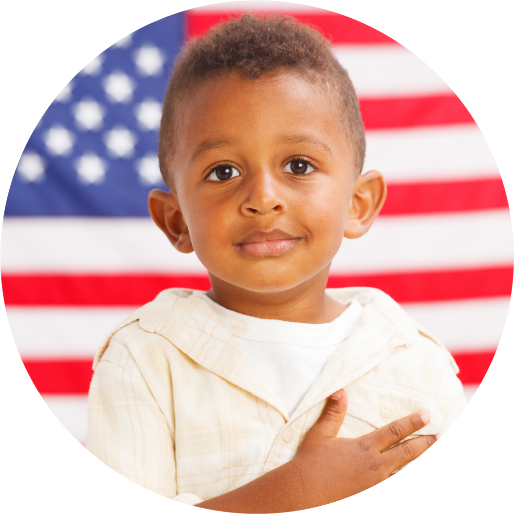 African american boy standing in front of American flag with hand over his heart