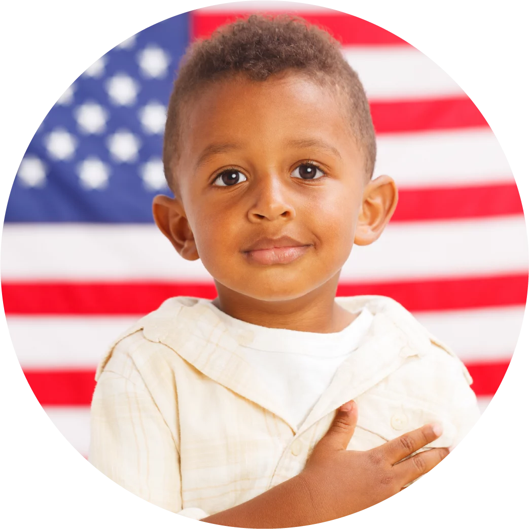 African american boy standing in front of American flag with hand over his heart