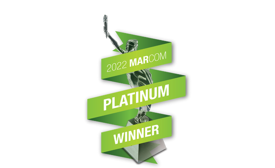 Award Trophy with Green 2022 MarCom Platinum Winner Banner wrapped around it