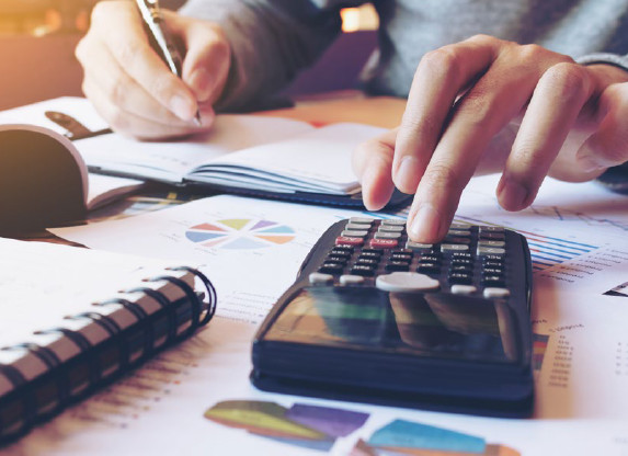 Man at desk performing calculations.